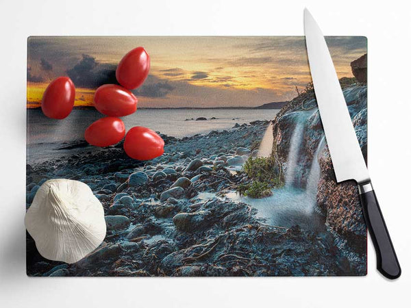 Water flows down the rocks into the sea Glass Chopping Board