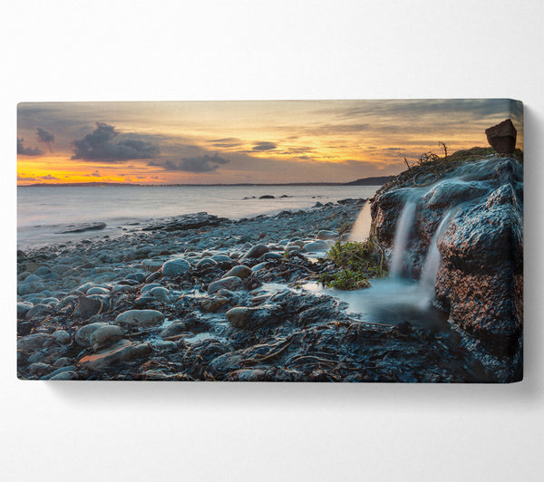 Water flows down the rocks into the sea