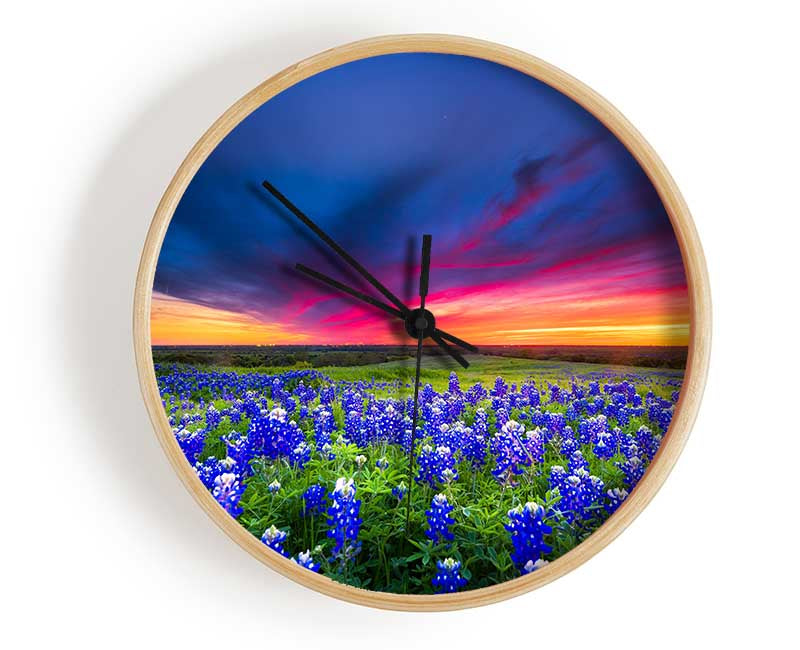 Vibrant skies above blue flowers Clock - Wallart-Direct UK