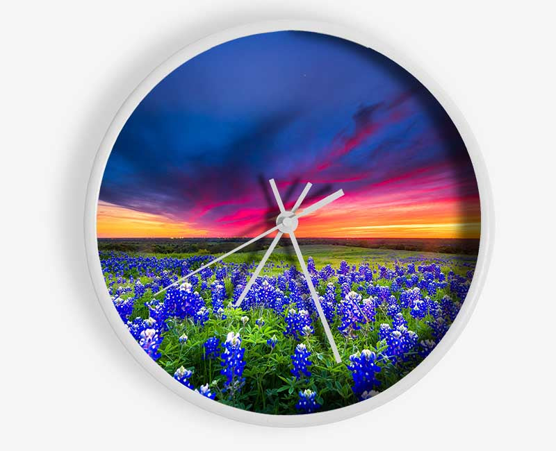 Vibrant skies above blue flowers Clock - Wallart-Direct UK