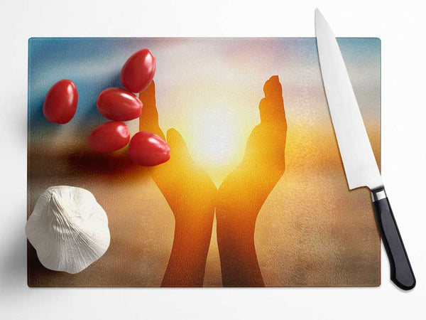 Sunset between hands Glass Chopping Board