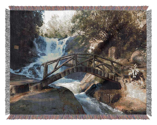 Rustic made bridge by a waterfall Woven Blanket